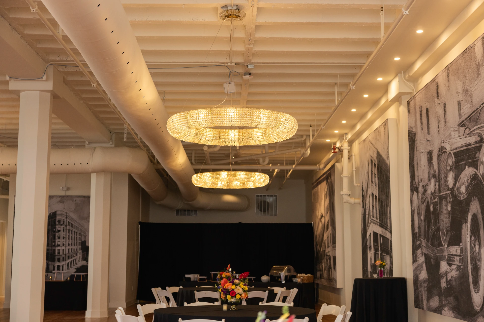 Crystal ring chandeliers above tables, with large Atlanta artworks on the ballroom wall.