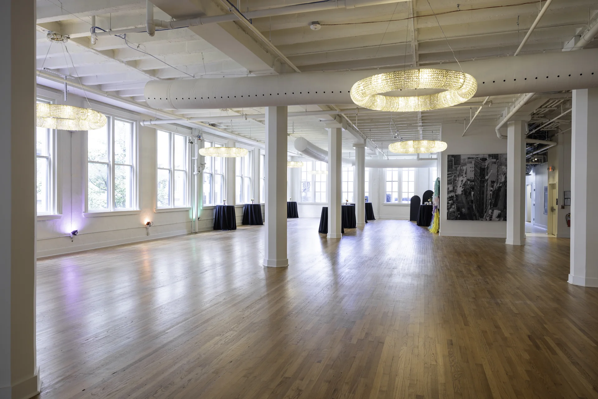 The length of Grand Ballroom with white columns, chandeliers, Atlanta artworks and tall windows.