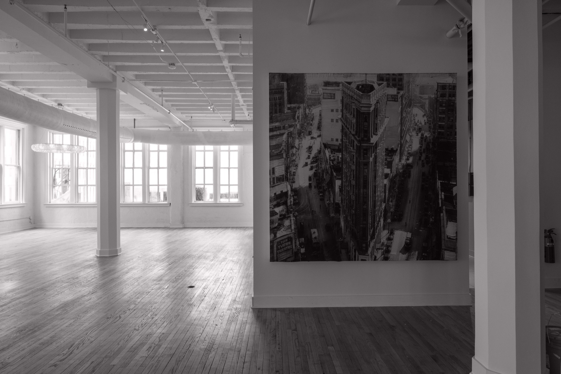 A large Atlanta city artwork mounted beside the ballroom’s white columns, windows and wood floor.